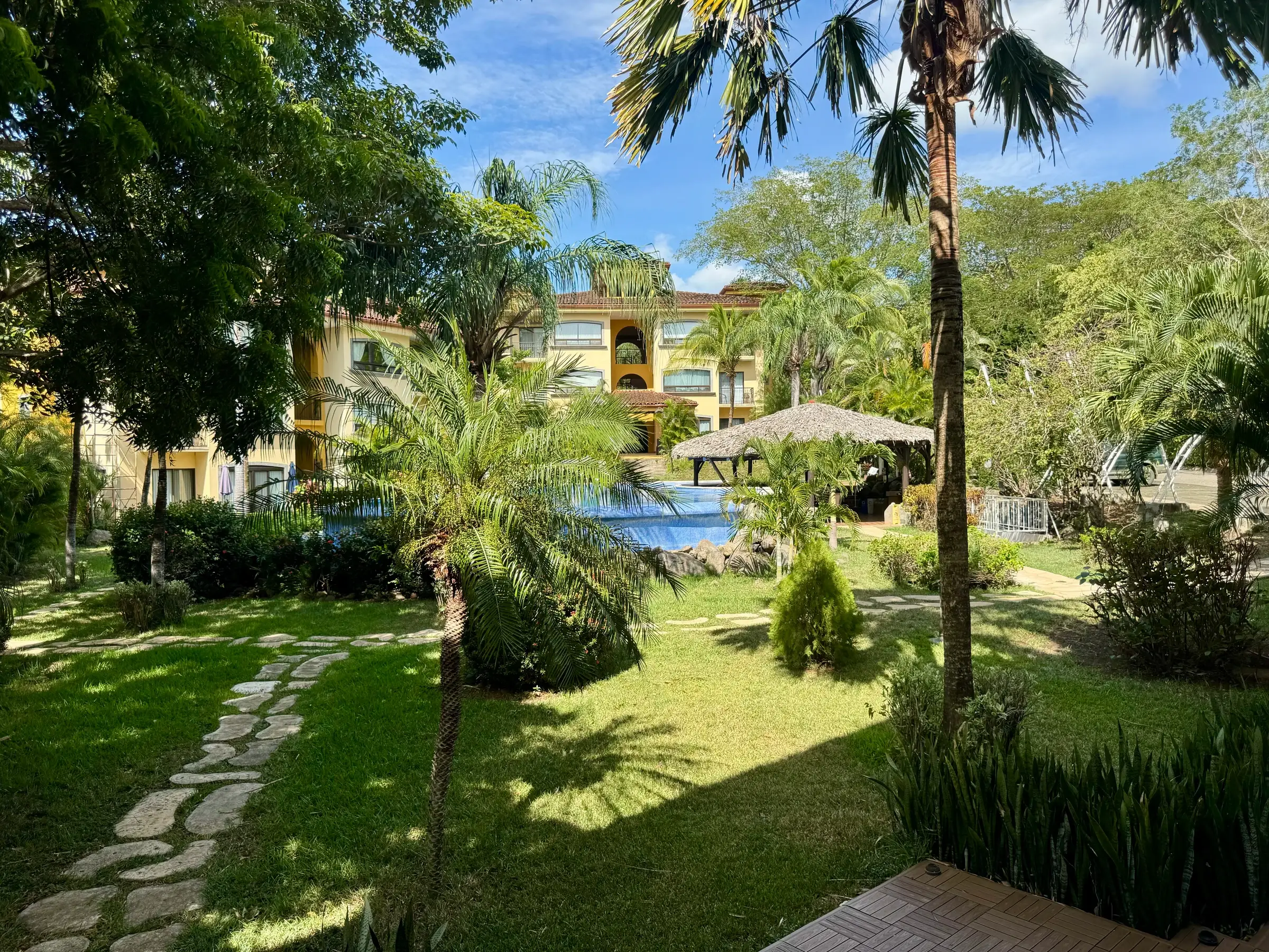 Pool, palms and lawns of The Oaks, Tamarindo, seen from the garden path