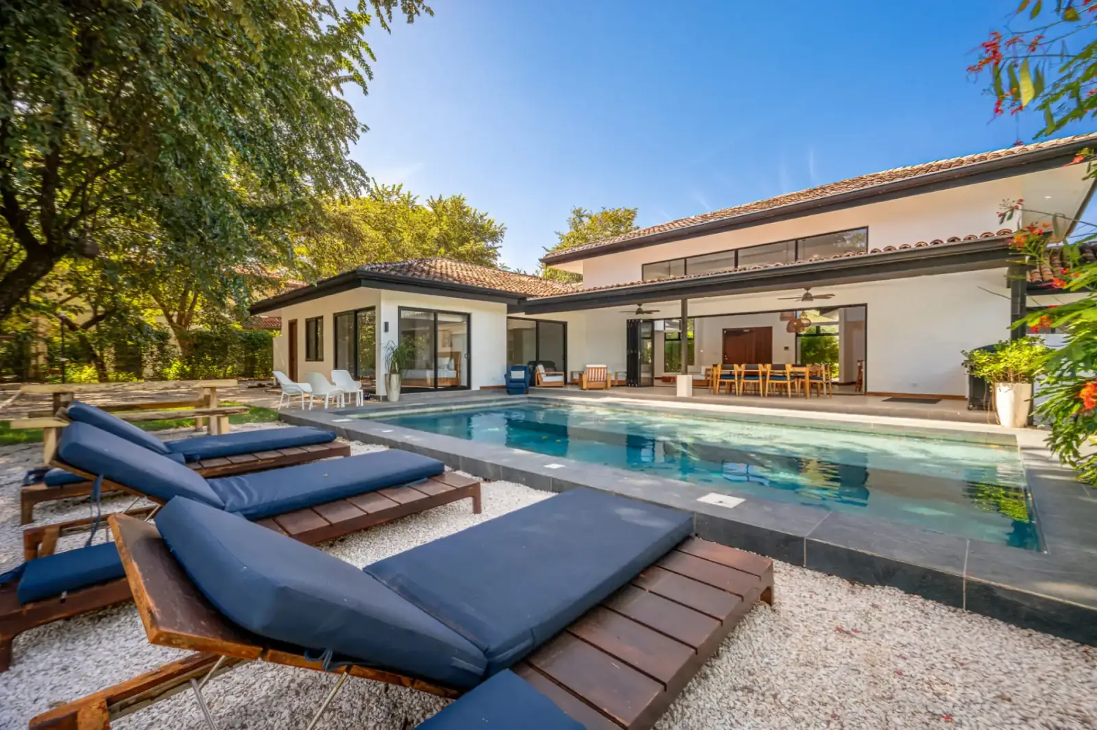 Poolside loungers facing a contemporary villa at Villa Brisa Marina, Hacienda Pinilla